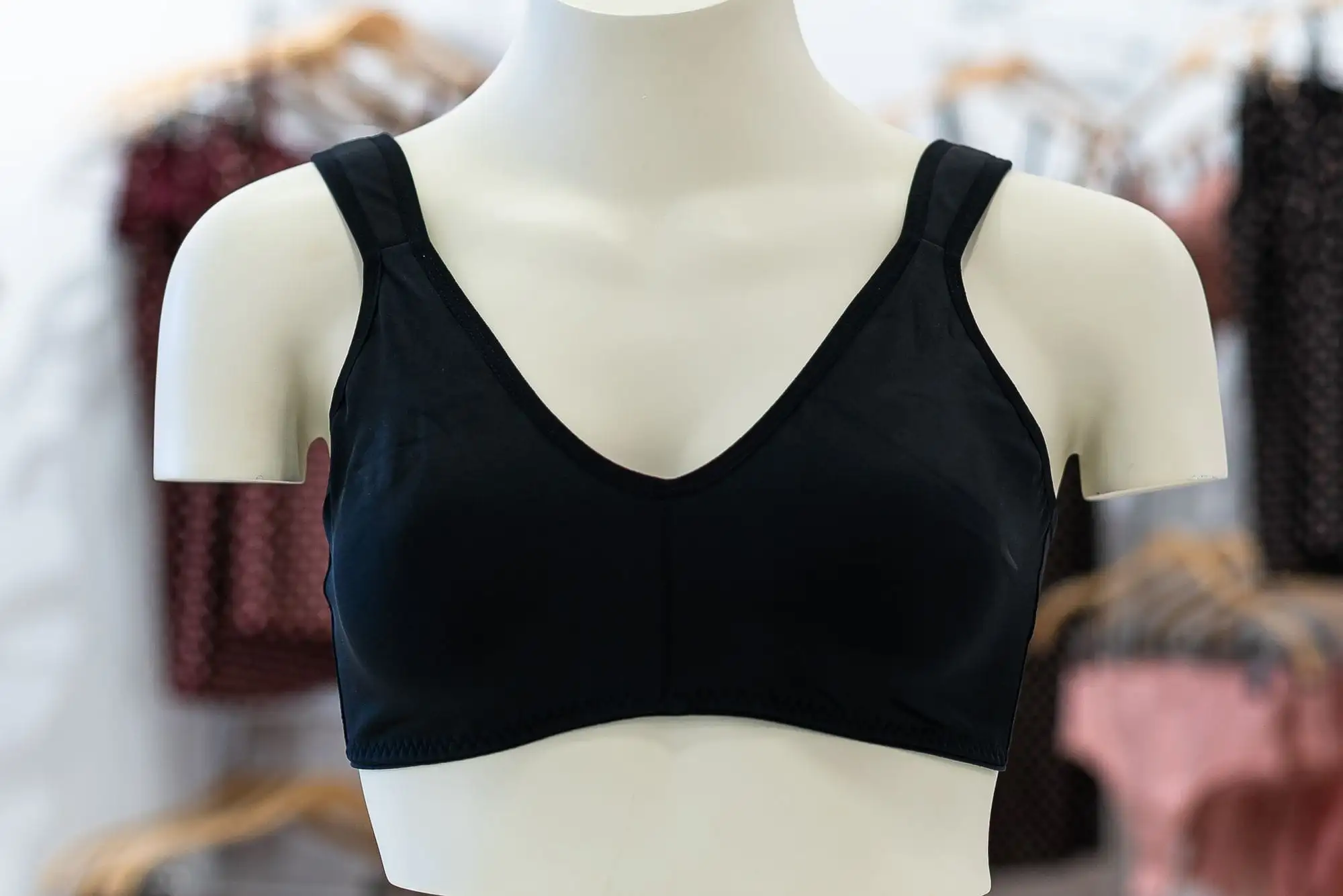 Sort blød bh uden bøjle med brede stropper på en hvid udstillingsbuste i en butik